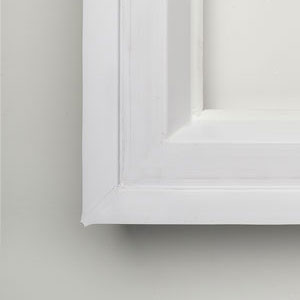 A white picture frame on the wall.