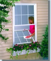 A woman is cleaning the window of her house.