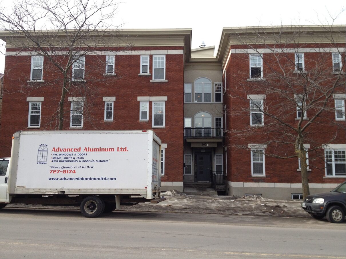 A moving truck parked in front of an apartment building.