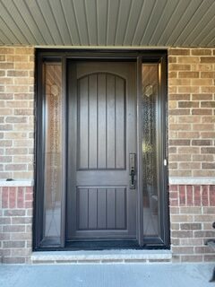 A front door with two side panels and one is painted black.