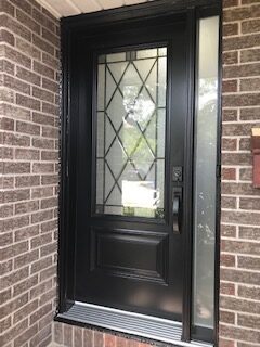 A black door with a glass window in the middle of it.