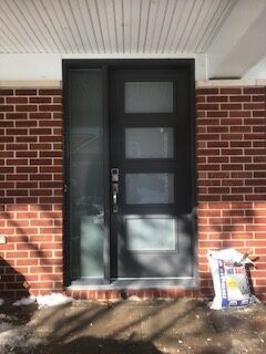 A black door with three glass panels on the side of it.