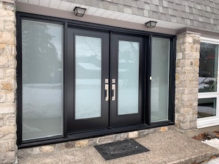 A black double door with frosted glass on the outside.