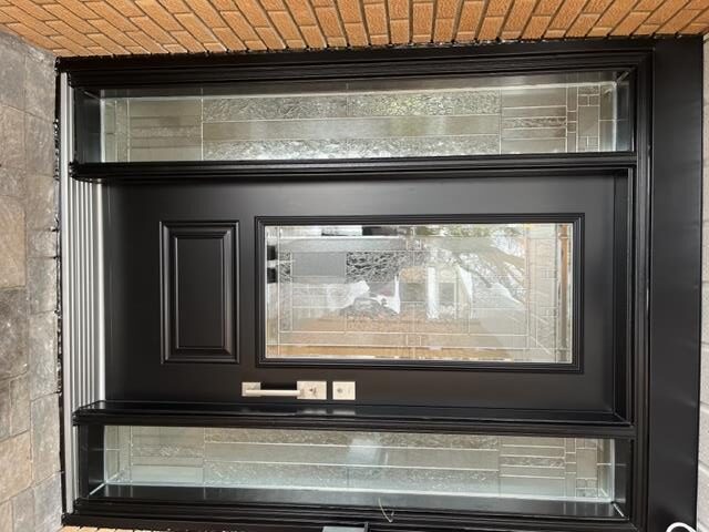 A black door with glass and tile on the inside of it.
