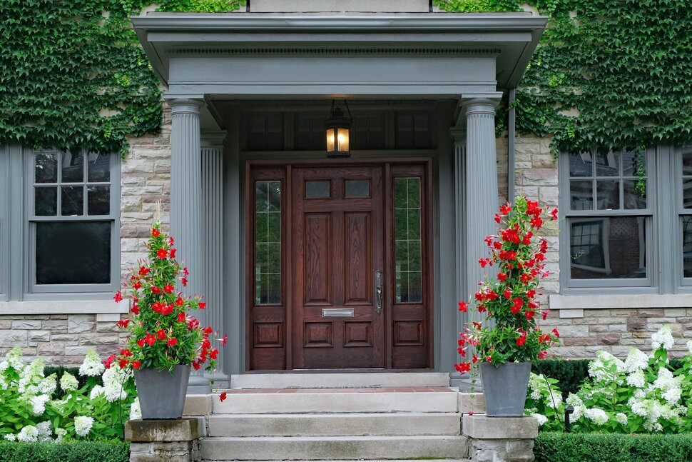 A front door with flowers in the center of it.