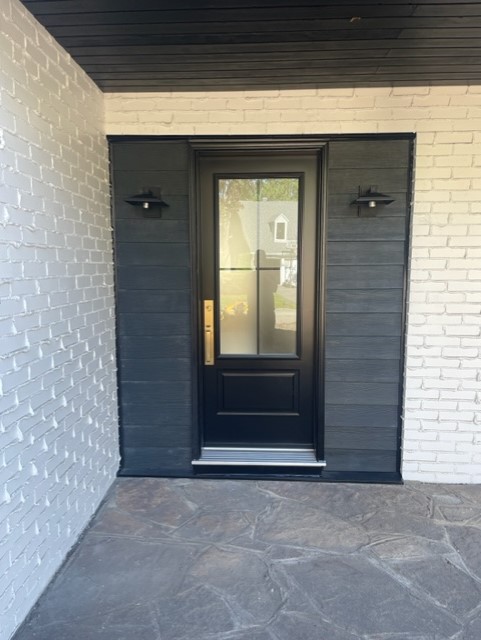 A black door with two lights on the outside of it.