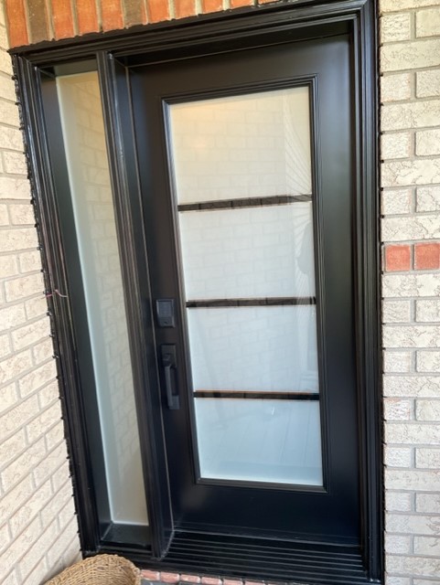 A black door with three glass panels on the side.
