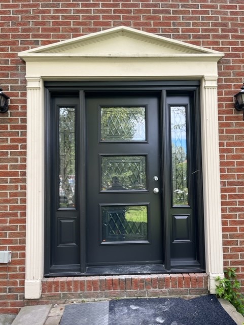 A black door with two windows and a white trim.